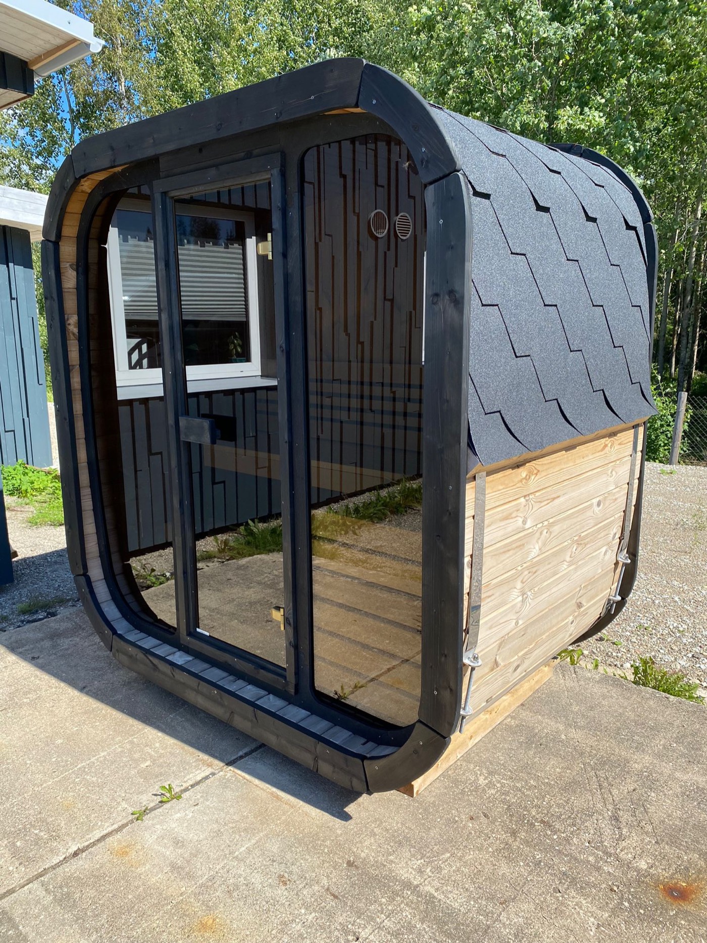 Lahti Mini with mirrored glass front reflecting the garden